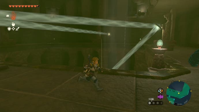 Link running next to a beam of light which is being reflected off a statue onto a level below in the Lightning Temple.