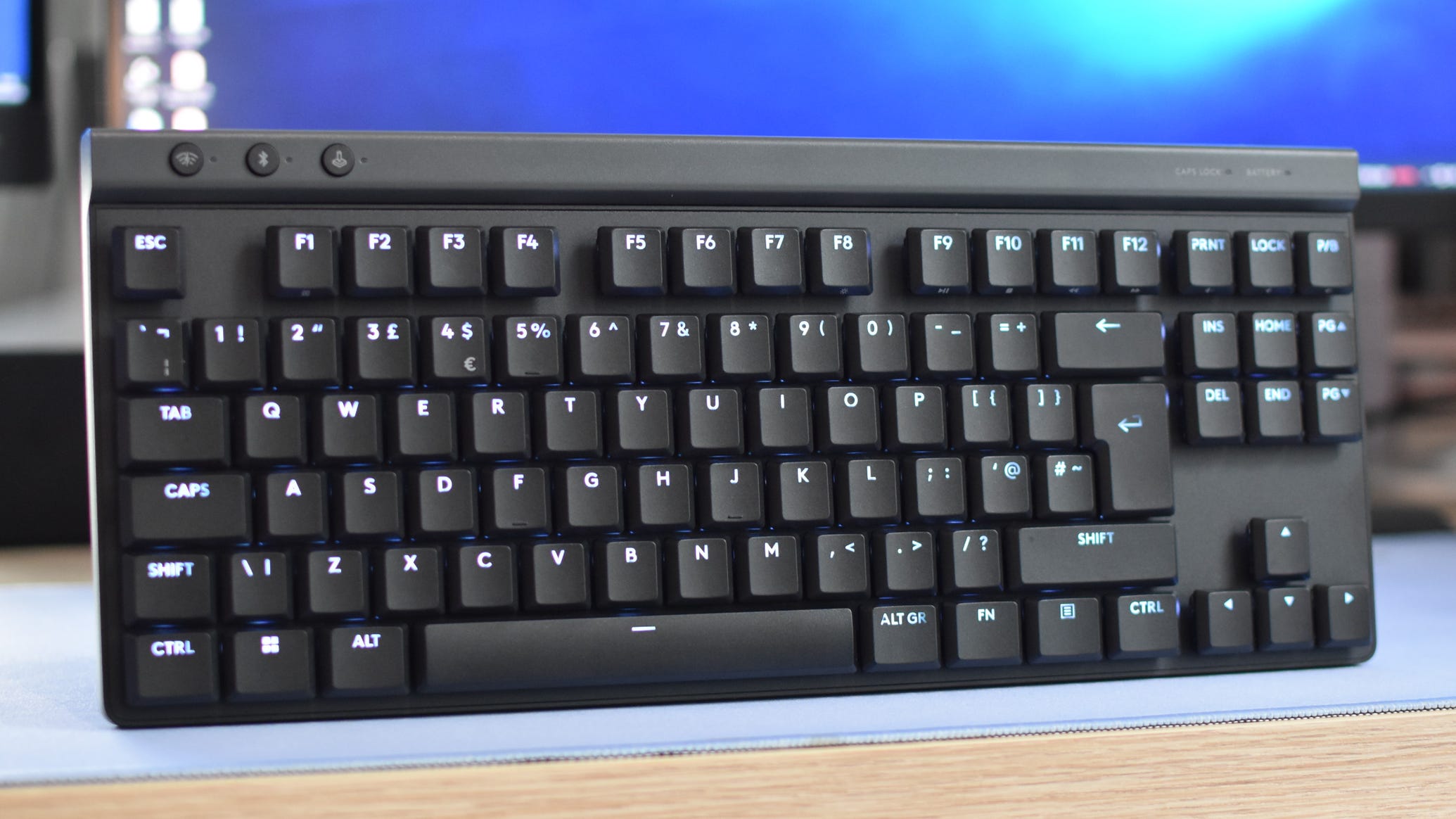 The Logitech G515 Lightspeed TKL gaming keyboard, propped upright connected a desk.