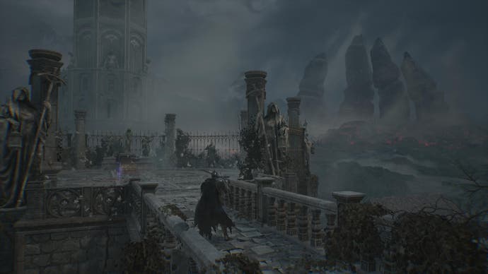 Player character in grey stone ruins with distant tower and mountains