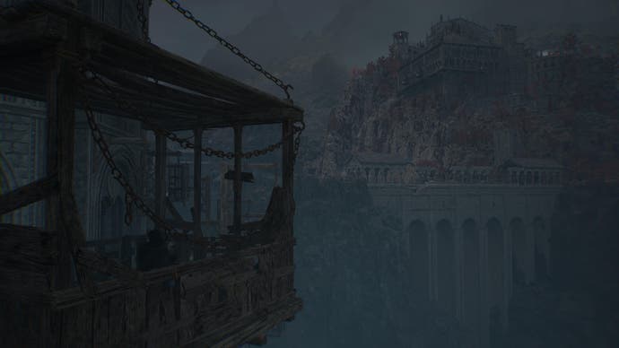 Player character in Lords of the Fallen on wooden lift looking at distant stone palace in grey light
