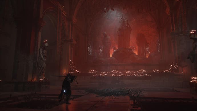 Player character in Lords of the Fallen in front of altar of statues and candles in red light