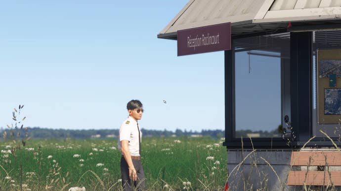 A pilot stands looking into a glass building, presumably at an airport, in MSFS 2024.
