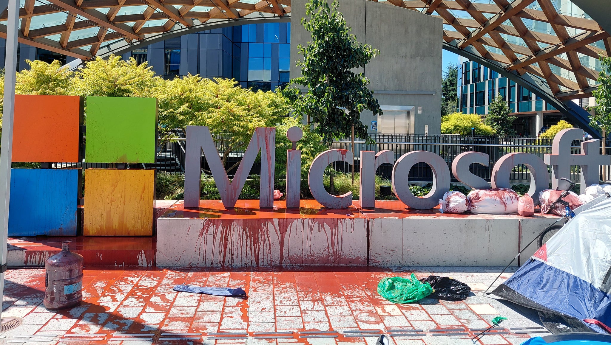 A photograph of a sculpted Microsoft logo outside their Redmond campus that has had red paint thrown over it in protest against the company's links to the Israeli military. - 4