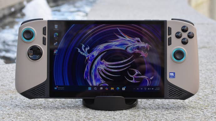 An MSI Claw 8 AI+, in an upright stand, sitting on an outdoor fountain.