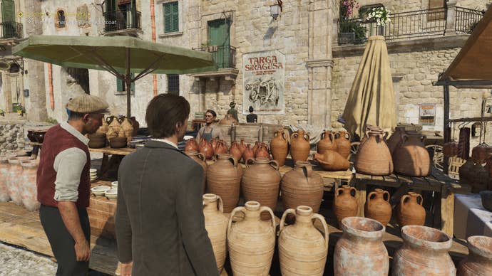 A masculine character surveys a vase-laden market stand in a stone-walled market square.