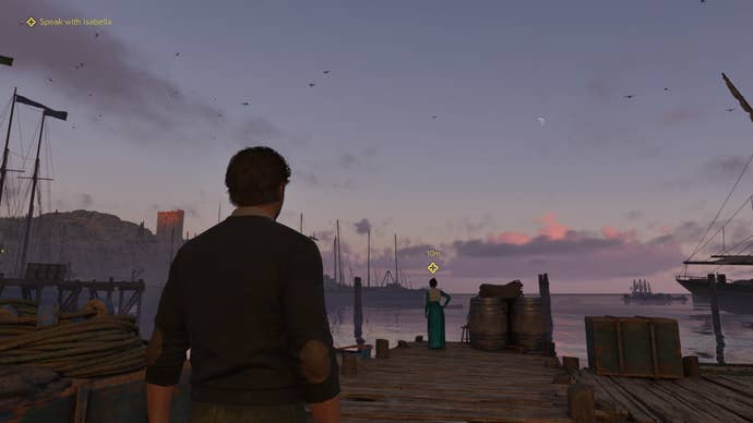 Over the shoulder of a masculine character down by a vintage jetty at dusk. The sun has turned the sky a peachy colour as it dips behind the horizon.