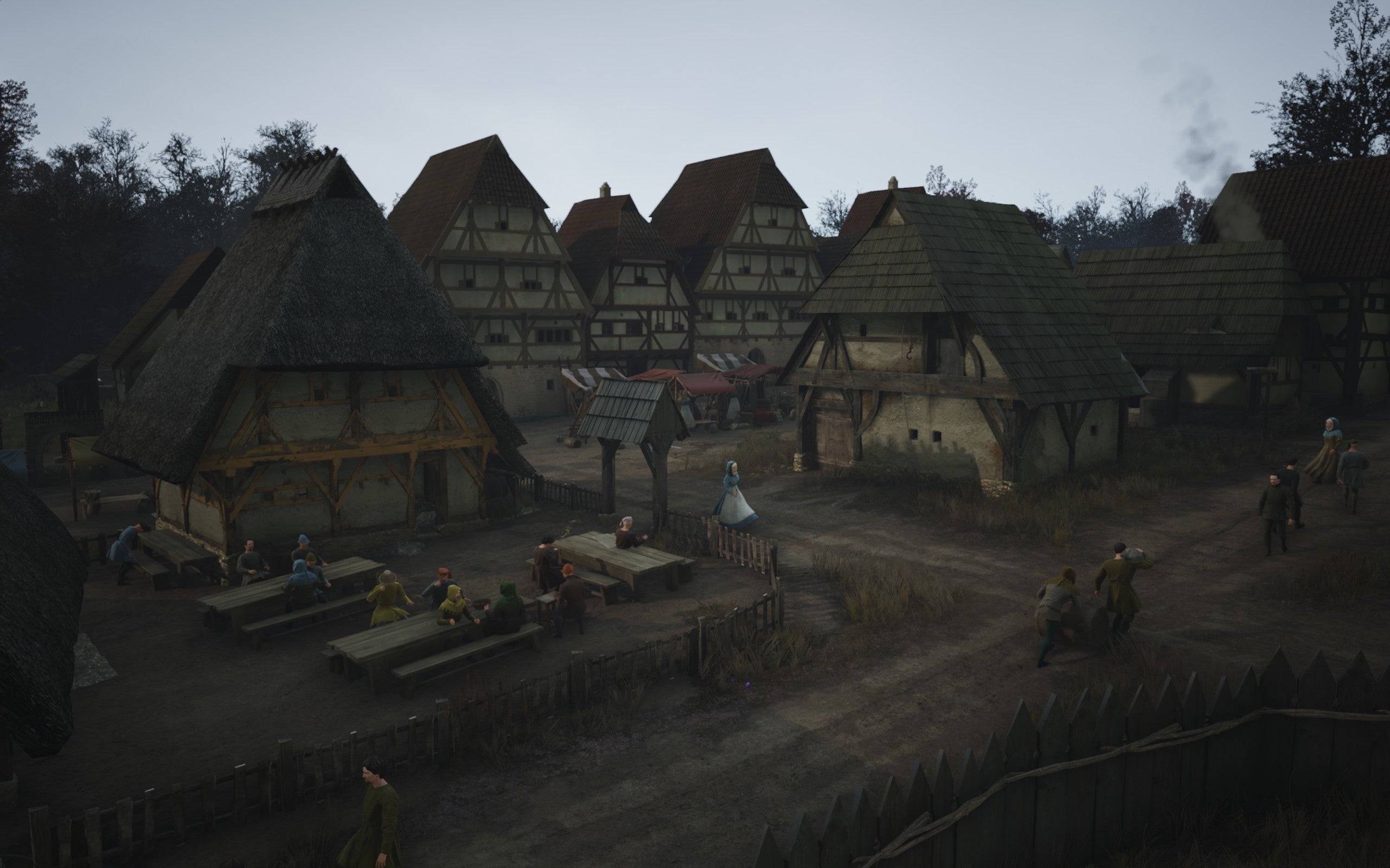 A busy town settlement with a tavern surrounded by large houses in Manor Lords.