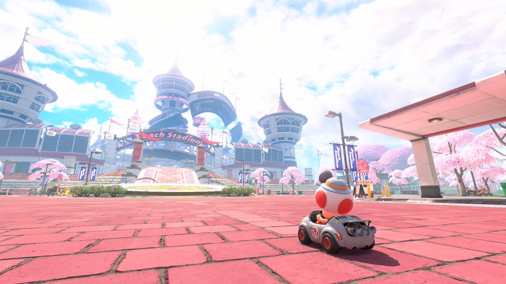 Toad is sat in the Baby Blooper in front of Peach's Stadium in Mario Kart World - 1