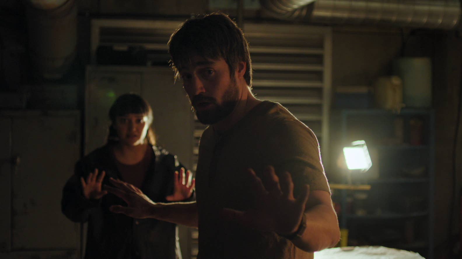 Mel and Owen in The Last of Us season two with their hands up