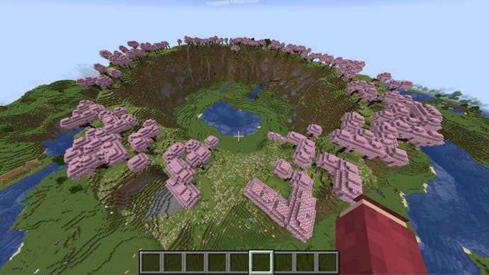 The player looks down at a circle of cliffs crowded with cherry blossom trees in Minecraft