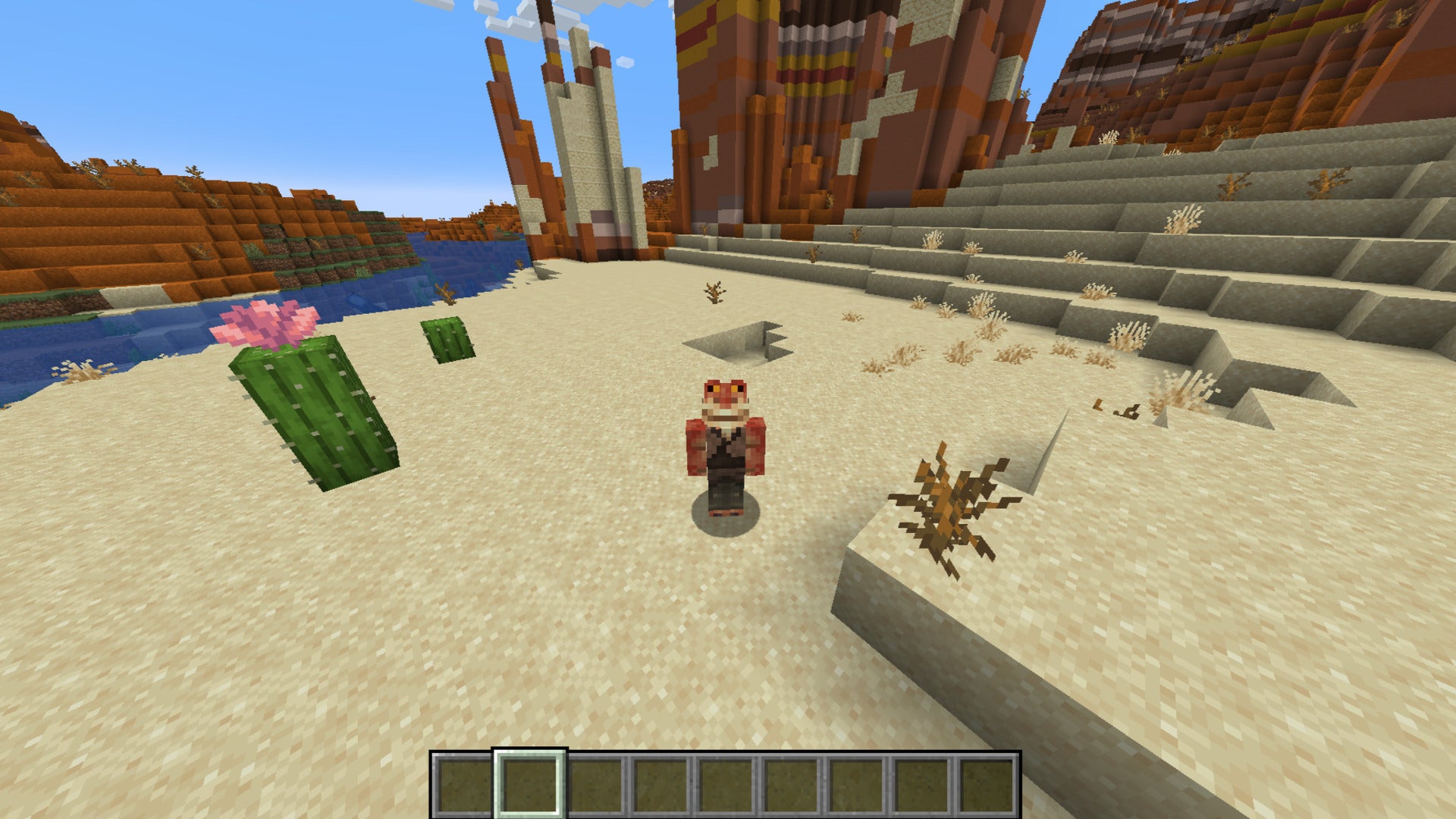 The player, wearing the Jar Jar Binks skin, stands in the desert - with the badlands behind them - in Minecraft