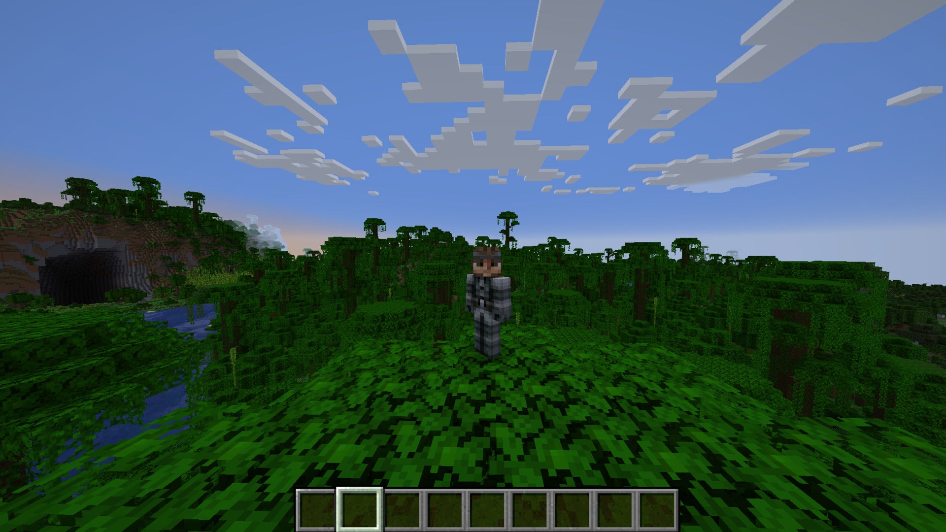 The player, wearing the Solid Snake skin, stands atop a tree in a jungle in Minecraft