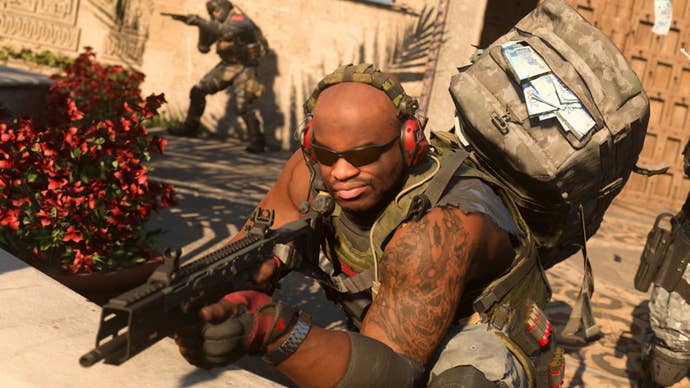 Modern Warfare 2 image showing a soldier aiming over a wall with their gun, while wearing a rucksack full of cash.