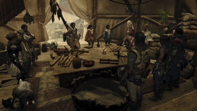 Monster Hunter Wilds screenshot showing a group of people surrounding a table with many scrolls on it inside of a tent.