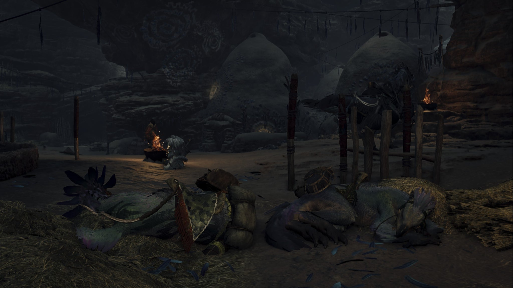 Dark Monster Hunter Wilds screenshot showing two sleeping Seikrets inside the Kunafa village with round stone houses in the background. - 7