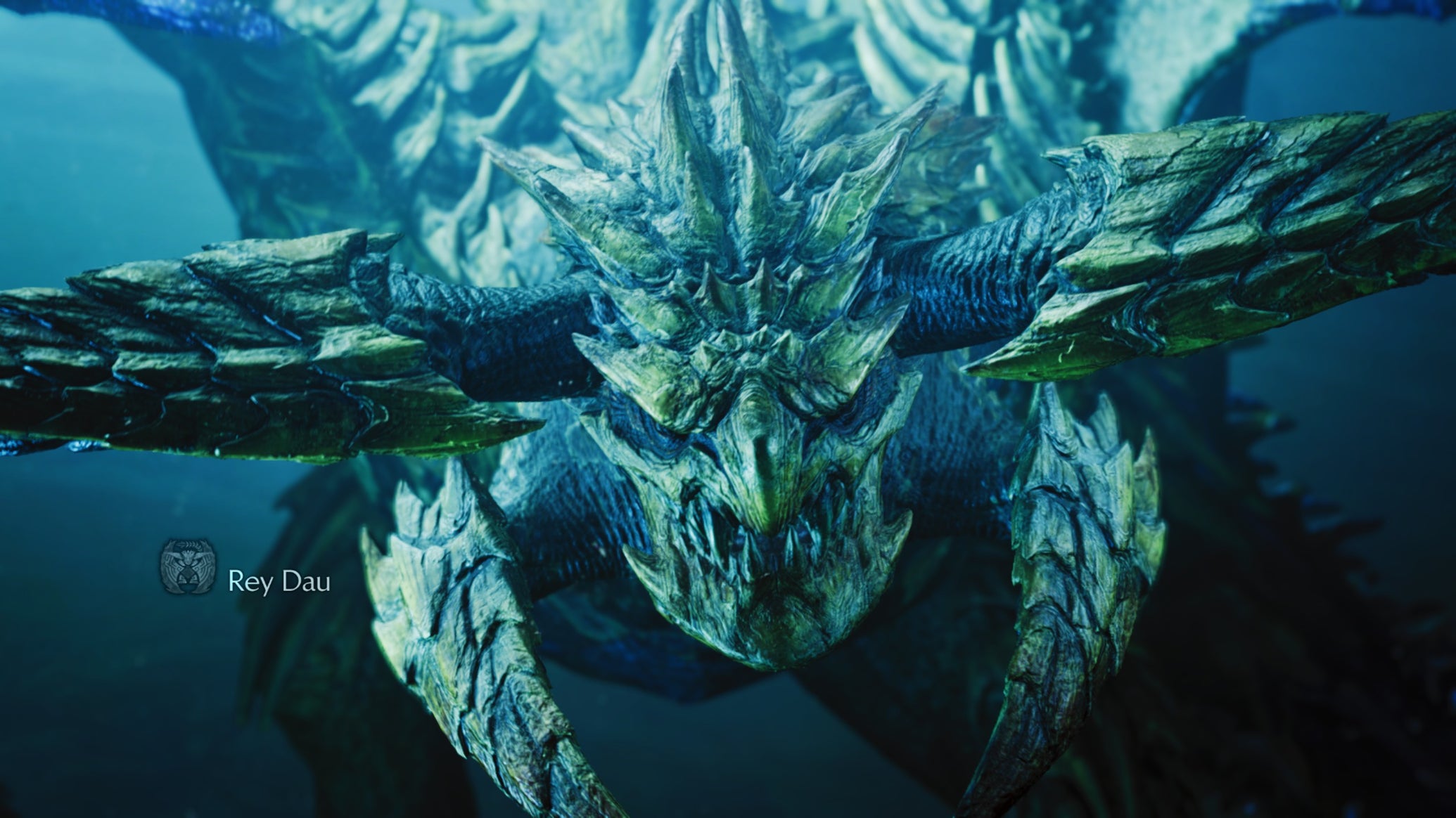 A Monster Hunter Wilds screenshot showing a close-up of the Rey Dau monster where you can see their yellow scales and horns around their face. - 1