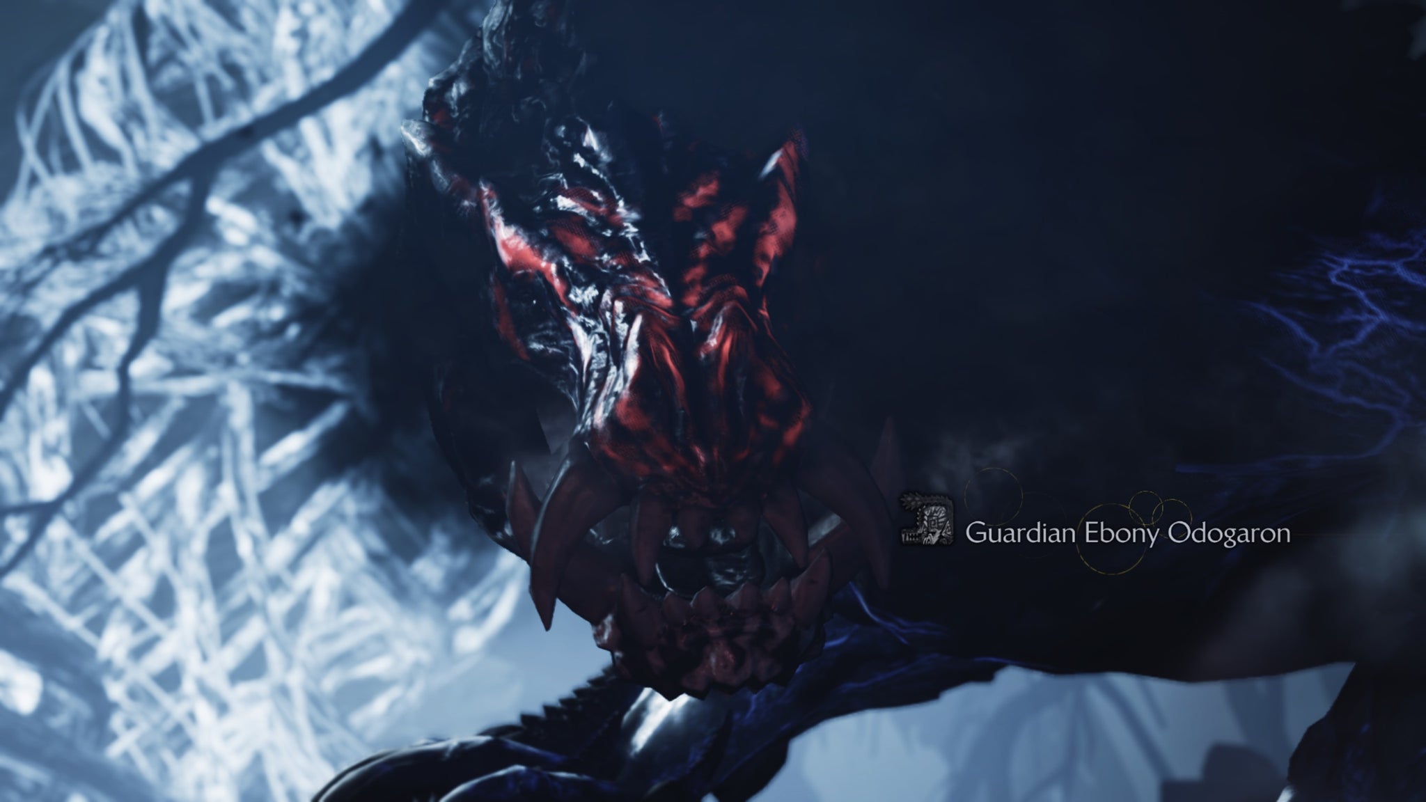 A Monster Hunter Wilds screenshot showing the Guardian Ebony Odogaron's glowing red face and their large teeth up close. - 5