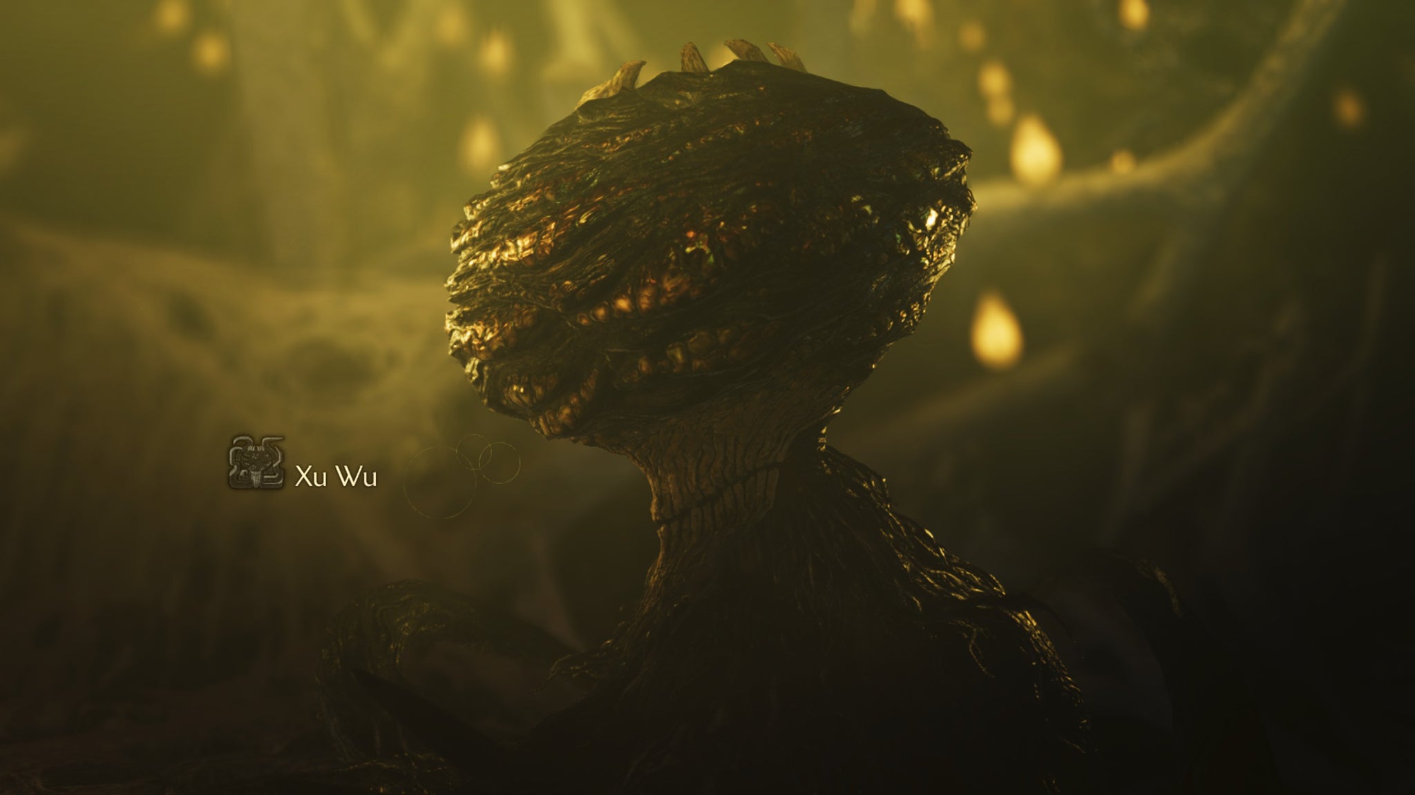 A Monster Hunter Wilds screenshot with yellow lighting showing the Xu Wu monster's large head with teeth sticking out the top. - 8