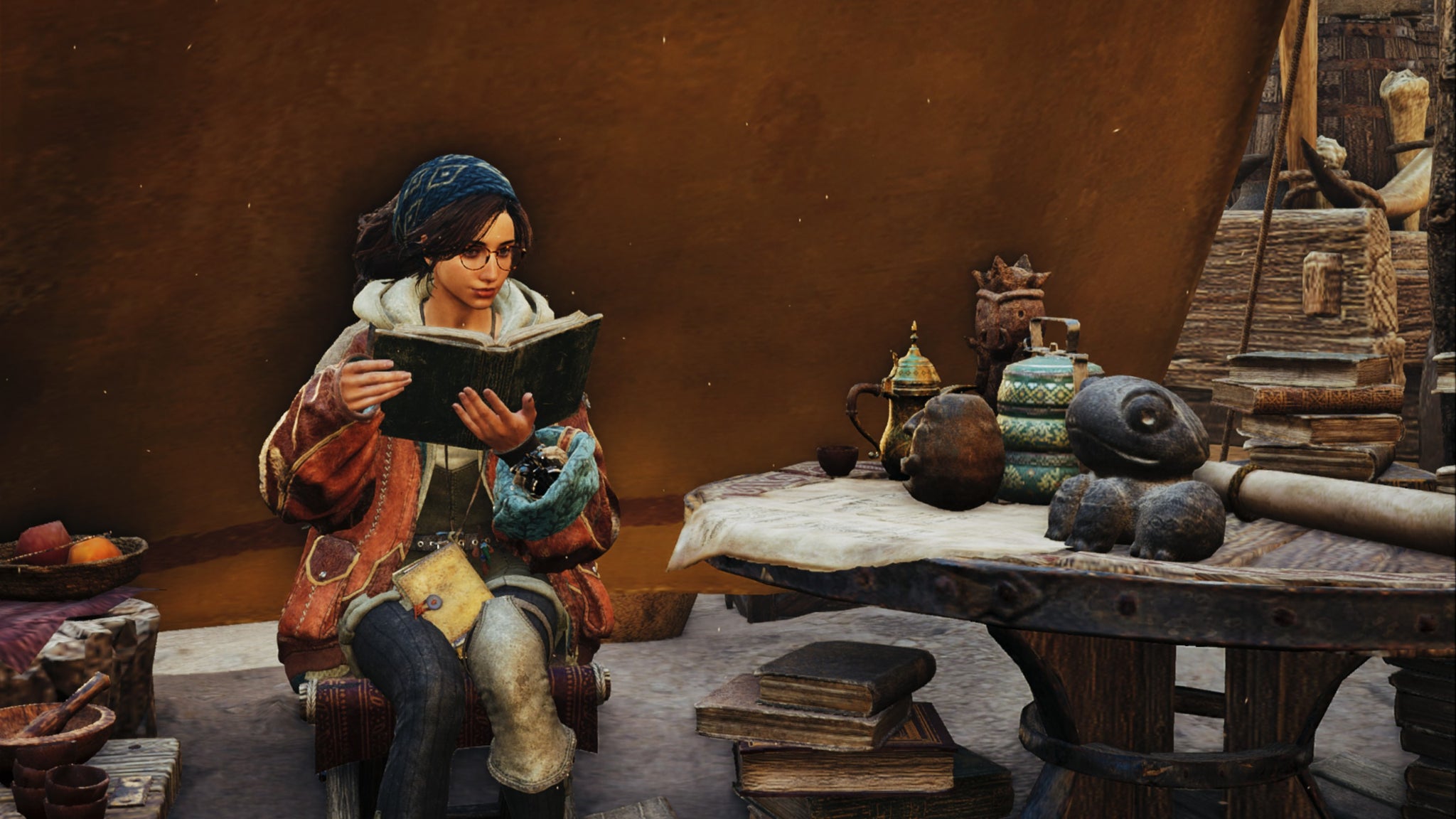 A Monster Hunter Wilds screenshot of Alma reading outside a tent near a table. - 4