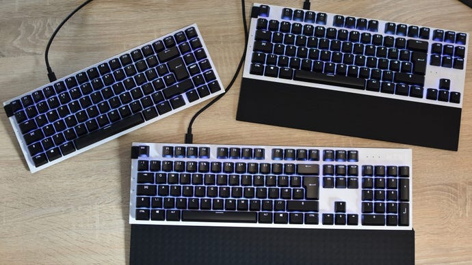 All three versions of the NZXT Function gaming keyboard series on a desk.