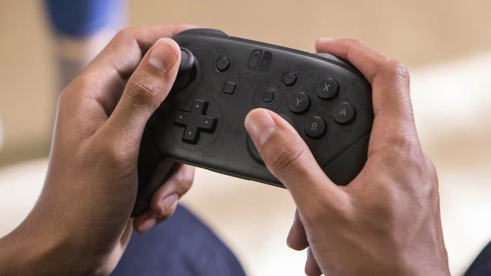 Person using a black Nintendo Switch Pro controller