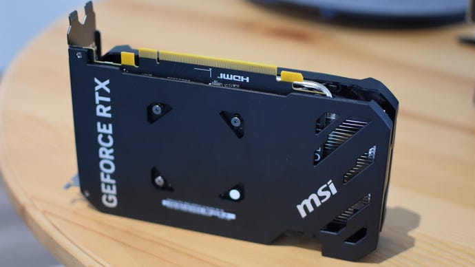 An MSI GeForce RTX 4060 Ventus 2X graphics card sitting on a table, with its backplate facing the camera.