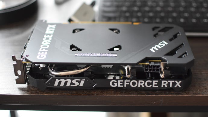 A side view of MSI GeForce RTX 4060 Ventus 2X graphics card, shoing parts of its cooling system and 8-pin power connector.