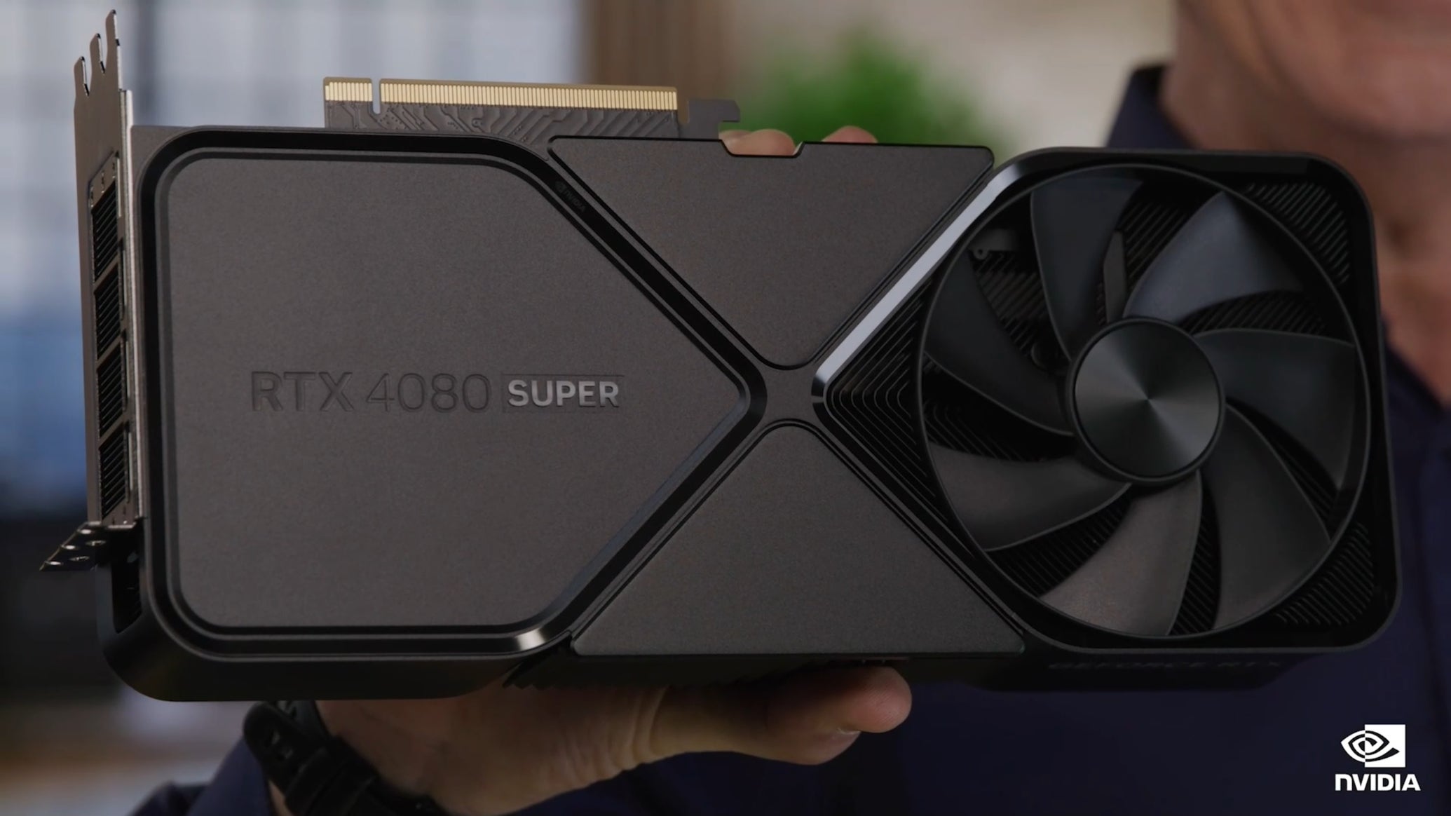 An Nvidia GeForce RTX 4080 Super graphics card being held up to the camera. - 1