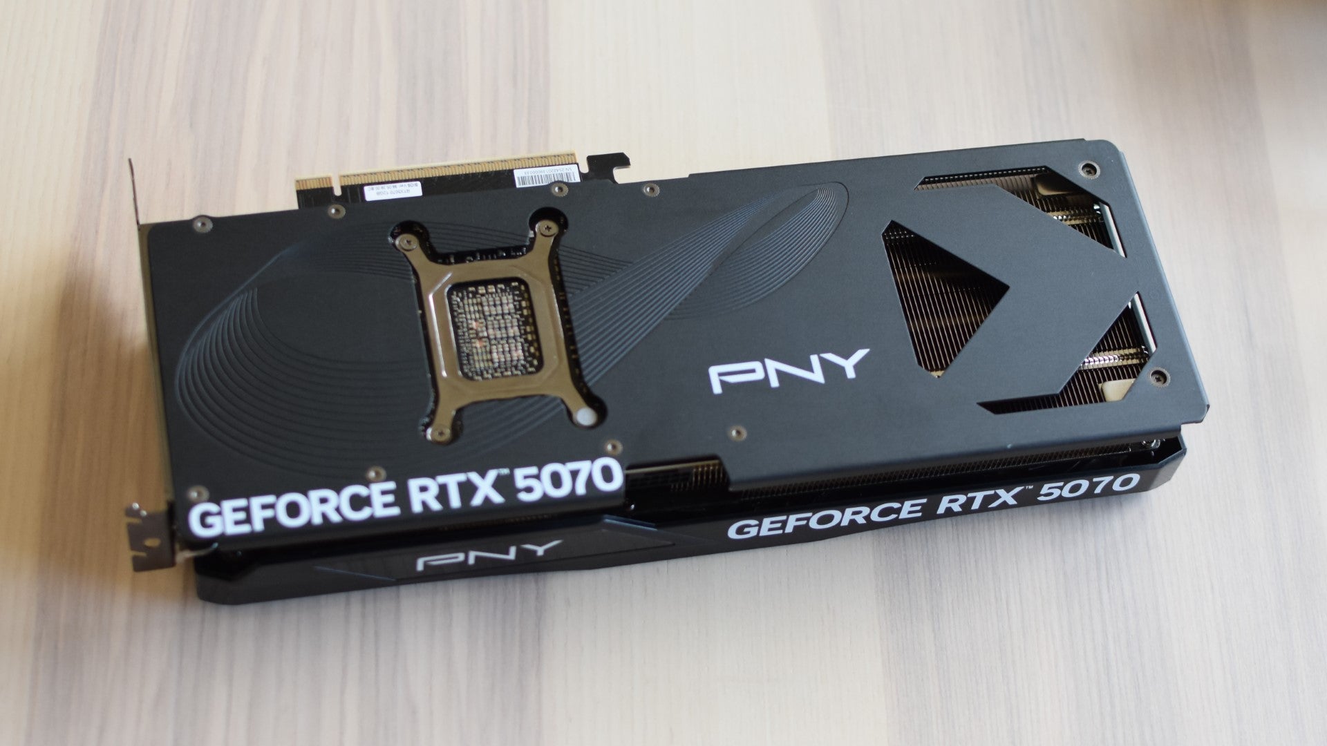 The PNY GeForce RTX 5070 OC on a table, backplate-side-up. - 5