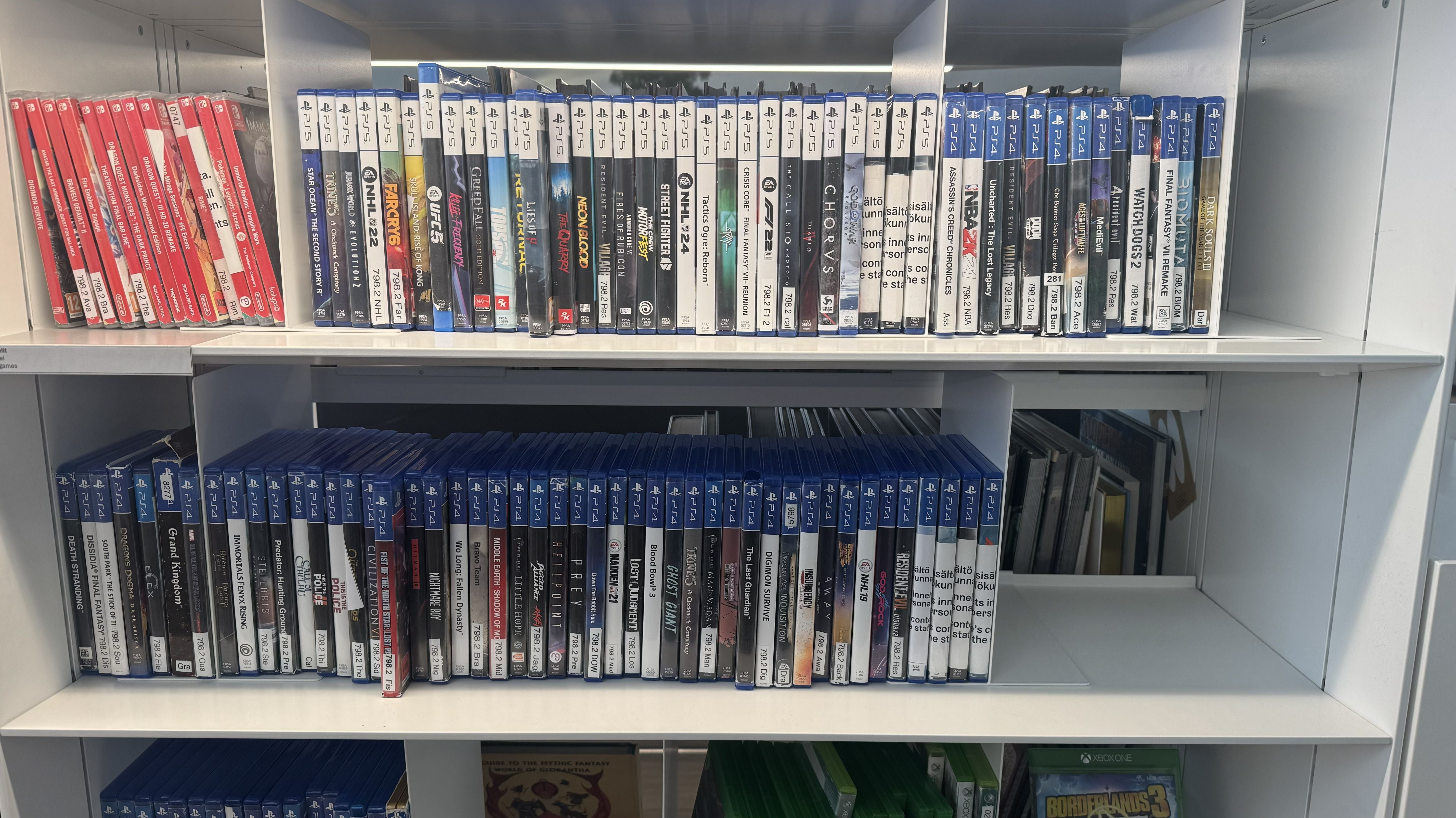 Photo of the Oodi Library in Helsinki showing Switch and PlayStation games on a white library shelf