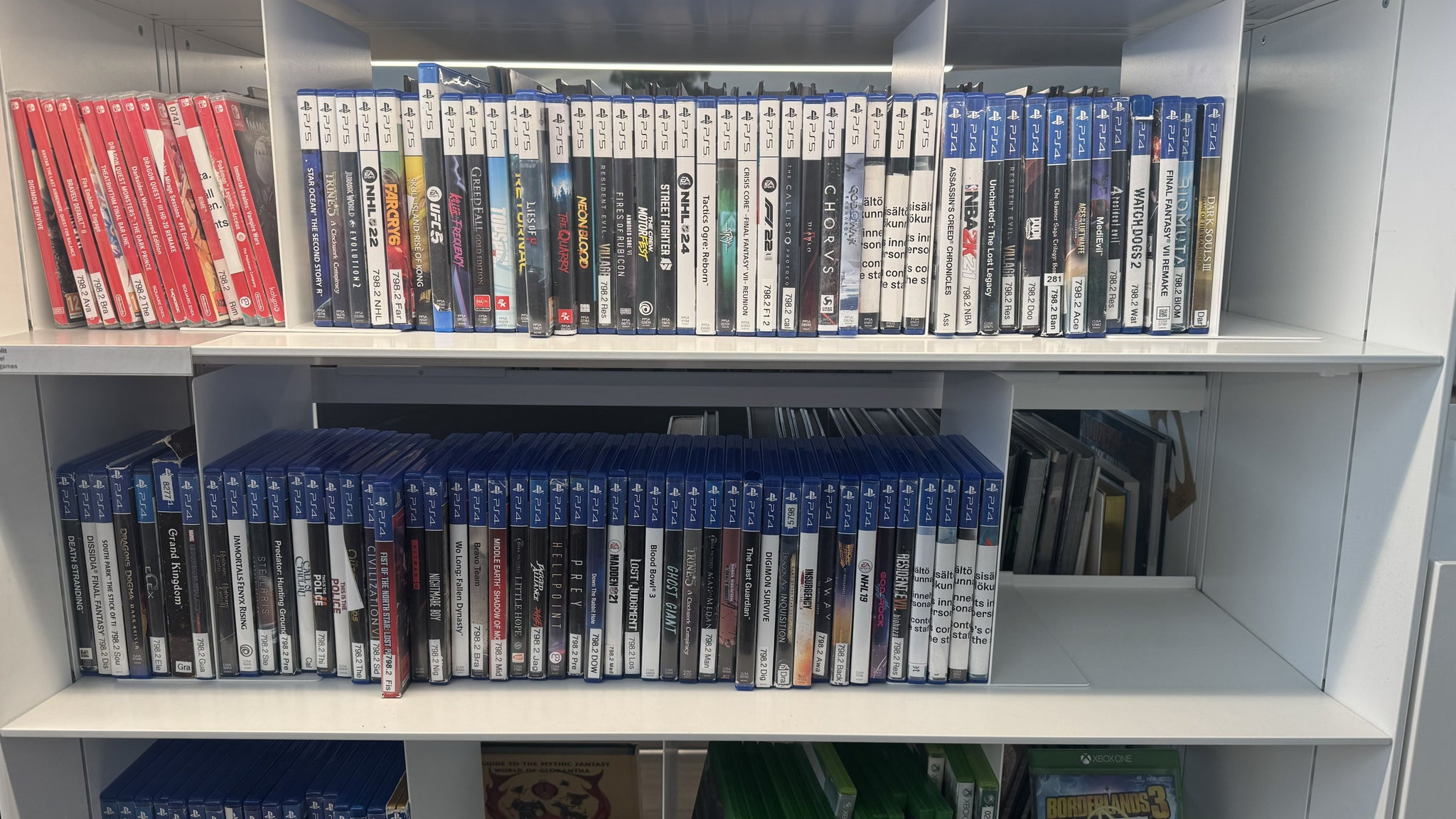 Photo of the Oodi Library in Helsinki showing Switch and PlayStation games on a white library shelf