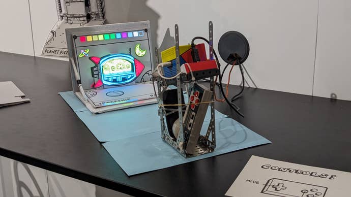 A photo of Bib Goes Home, a cardboard flip book and a projector at the EGX Leftfield Collection 2023