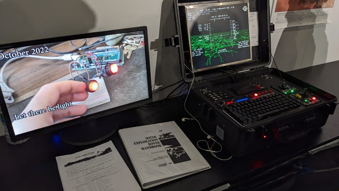A black box with a custom PC controller inside it, next to a folder and a screen showing the making of Lost On Mars at the EGX Leftfield Collection 2023