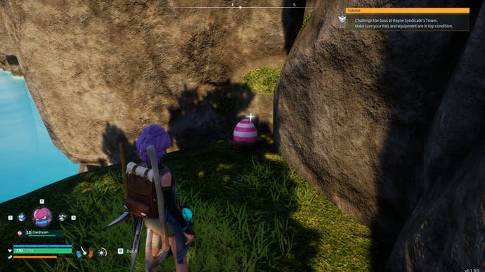 A purple-haired character approaches a Common Egg in the wild, that's located in a grassy area with a cliff, in Palworld.