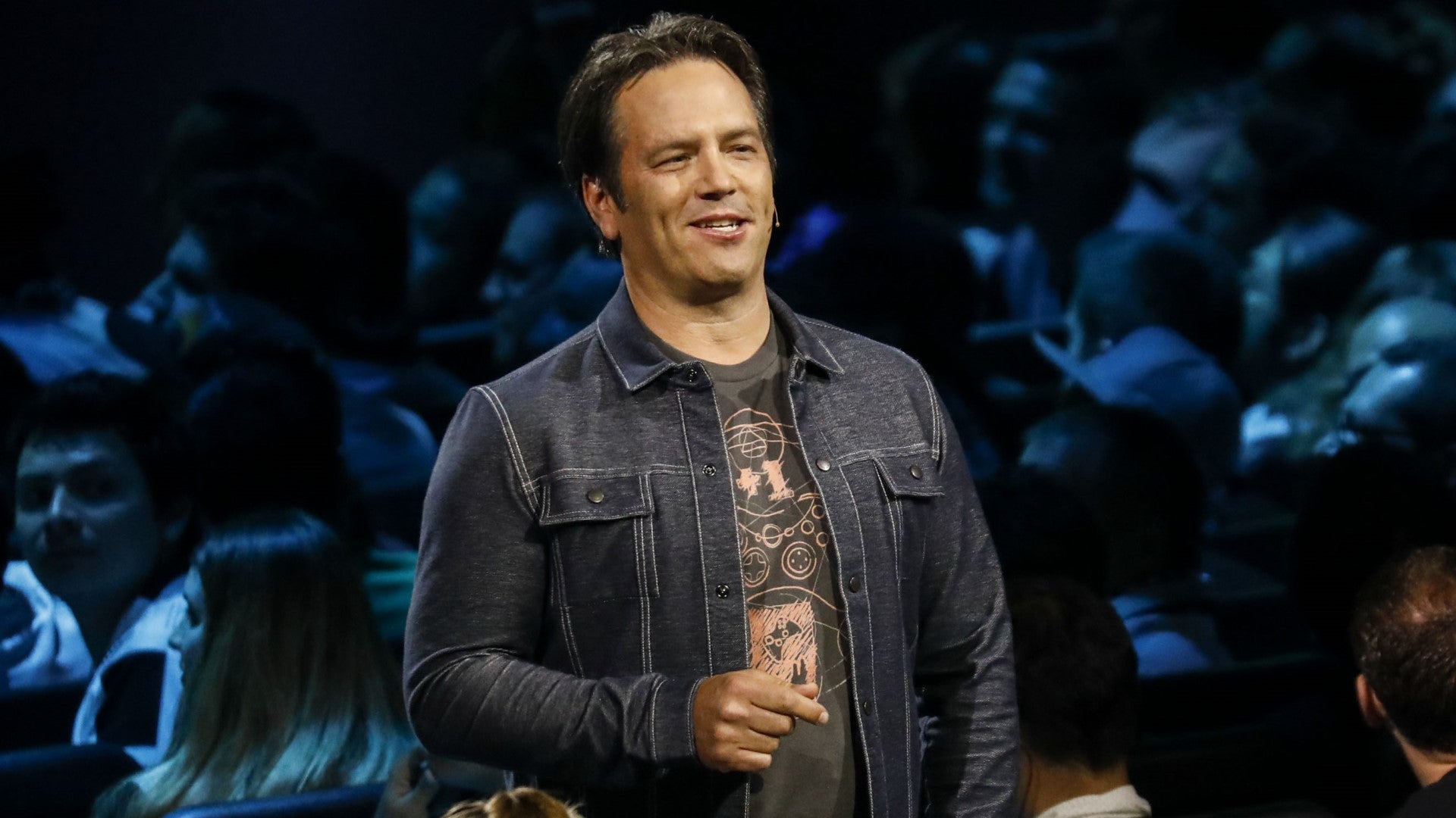 Microsoft executive Phil Spencer in a denim jacket and T-shirt addressing a crowd - 1