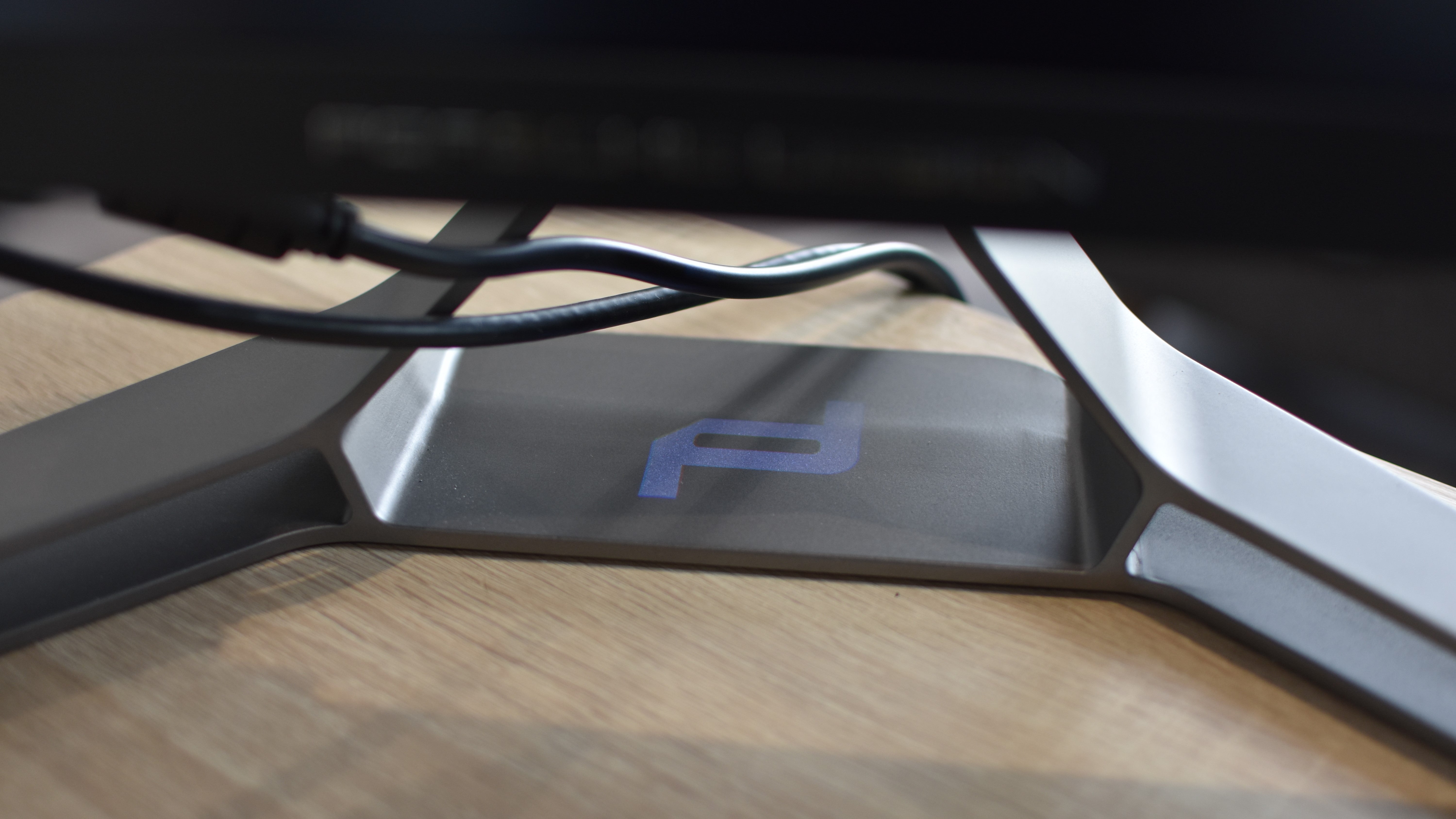 A decorative Porsche Design light projecting onto the base of the Porsche Design AOC Agon Pro PD32M gaming monitor.