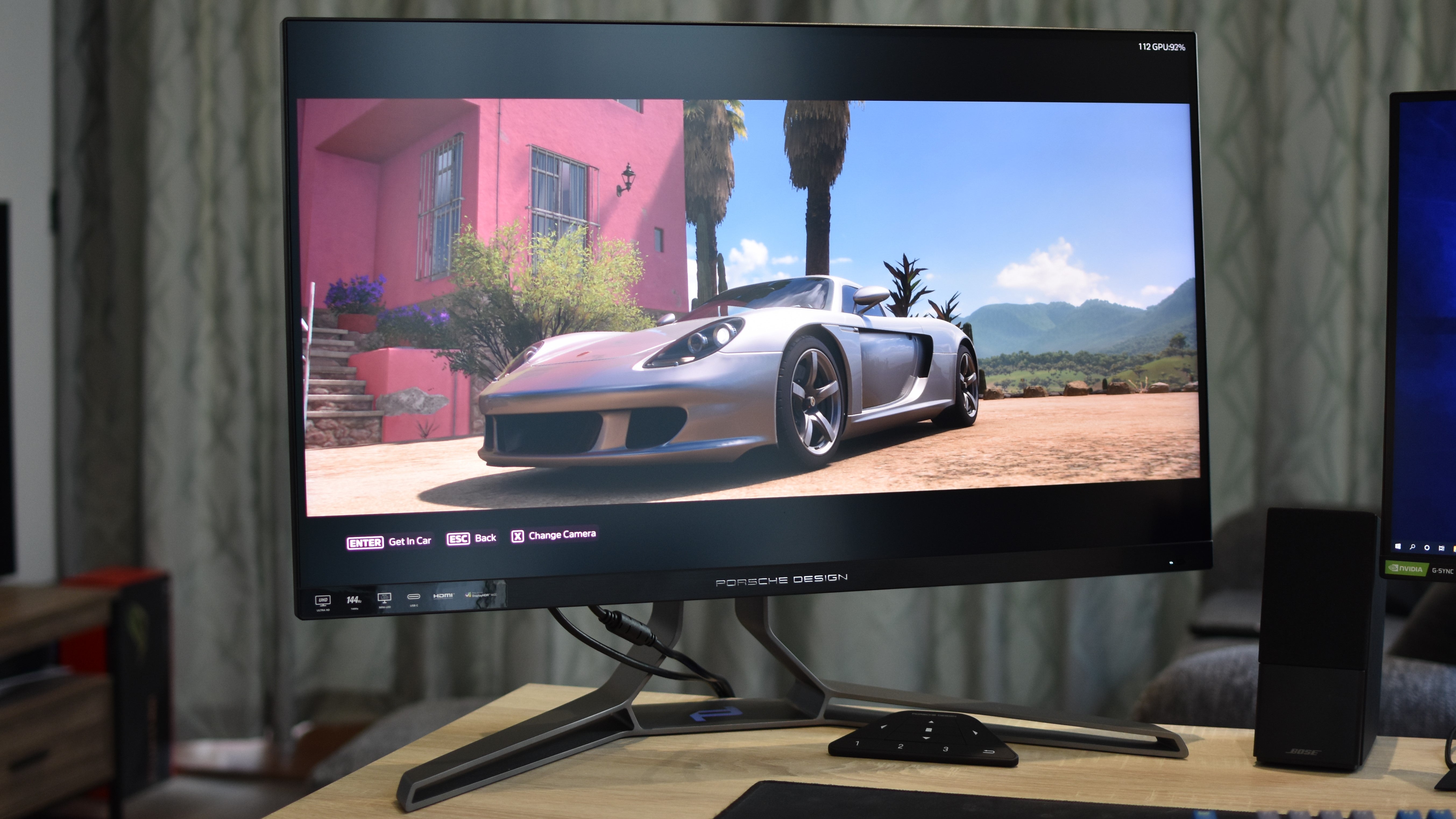 The Porsche Design AOC Agon Pro PD32M on a desk, showing a Porsche car in Forza Horizon 5.