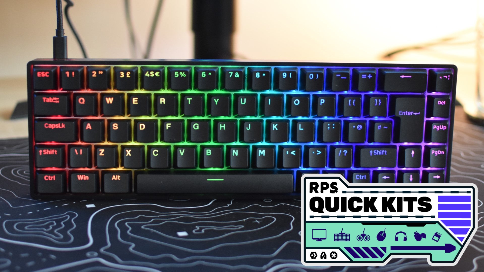 The QPAD Flux 65 Model 5 propped up on a desk. The RPS Quick Kits logo is added in the bottom right. - 1