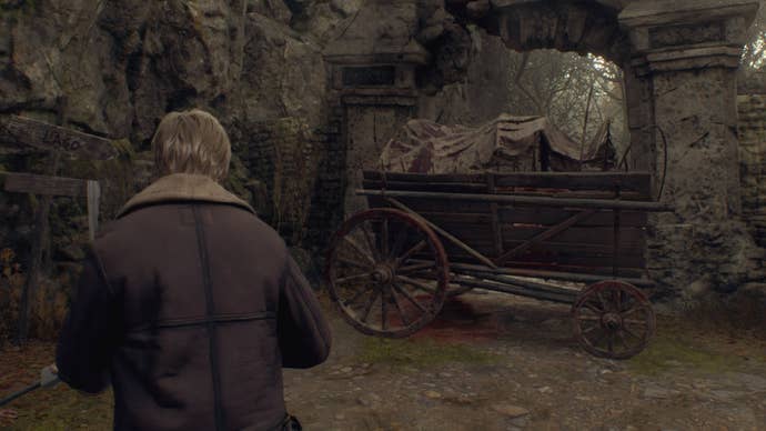 Leon looks at a cart with a dead cow in it that needs moving in Chapter 1 of the Resident Evil 4 remake