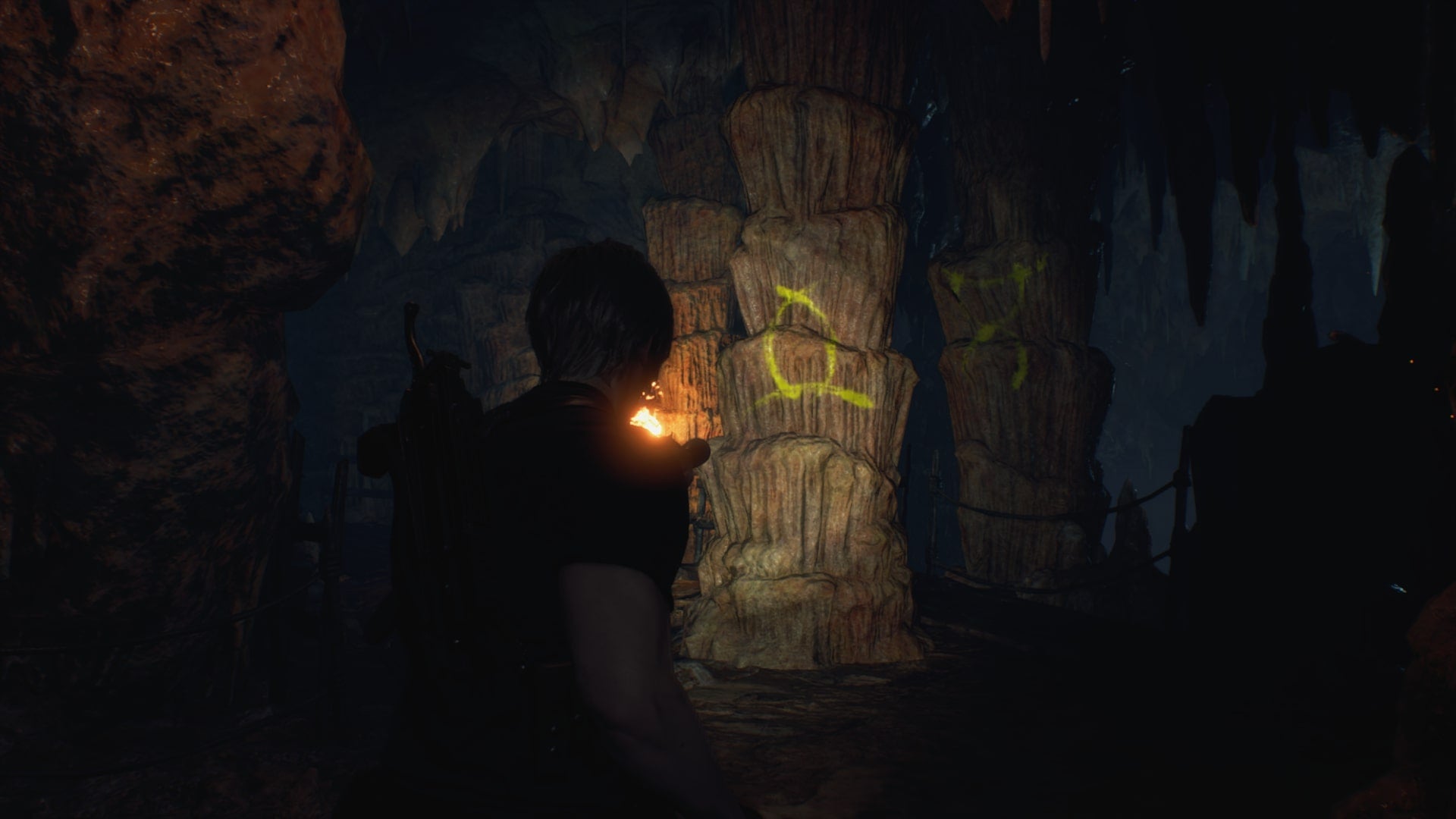Leon shines his torch on a symbol required for the Cave Mural puzzles  in Resident Evil 4 Remake