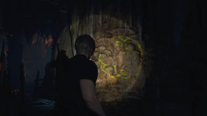 Leon shines his torch on a symbol required for the Cave Mural puzzles  in Resident Evil 4 Remake