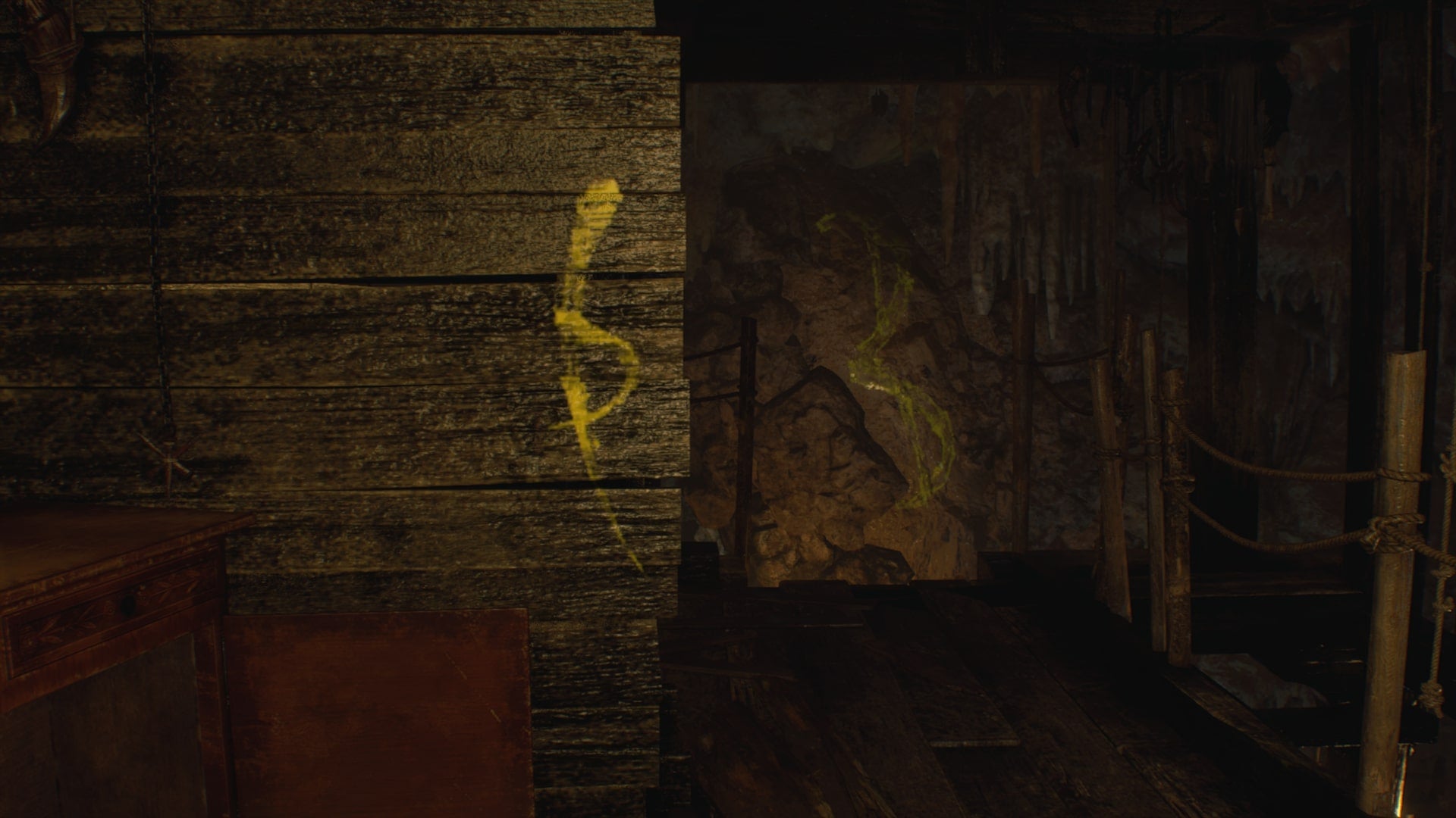 Leon shines his torch on a symbol required for the Cave Mural puzzles in Resident Evil 4 Remake - 10