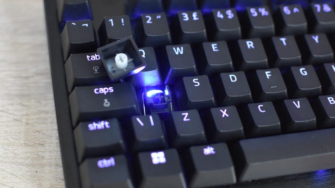 A Razer Huntsman V3 Pro Tenkeyless with its A key removed, showing the mechanical switch within.