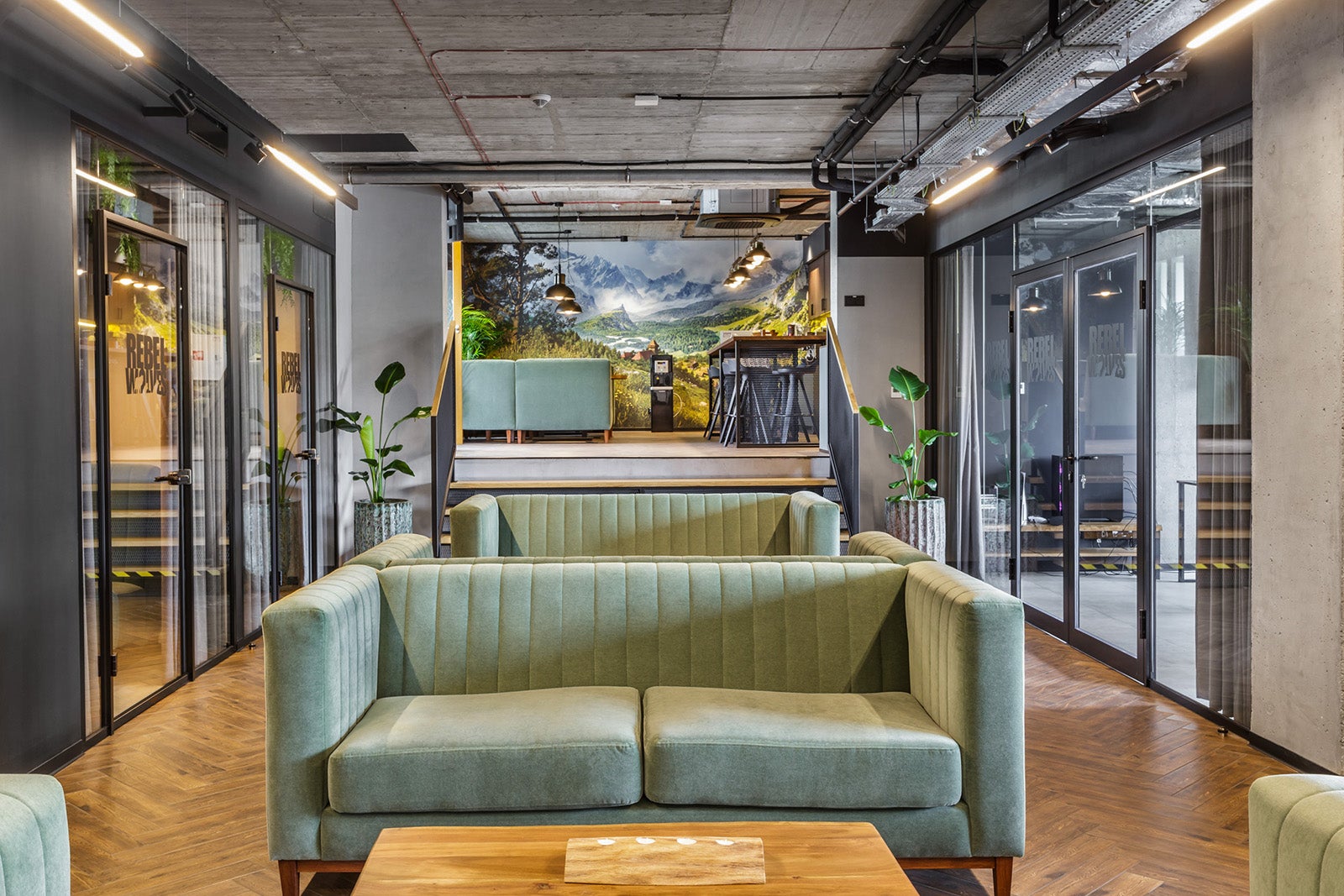 Green sofas and glass walls in the inside of a modern-looking office. It's Rebel Wolves' office in Poland, the developer of The Blood of Dawnwalker.