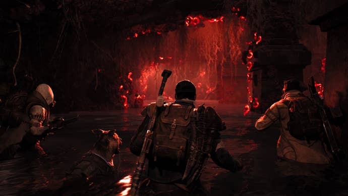 Three gunners walk into a dark, red cave in Remnant 2