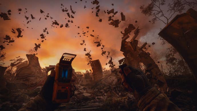 The player watches rubble levitate in the air while holding a handheld machine in Stalker 2.