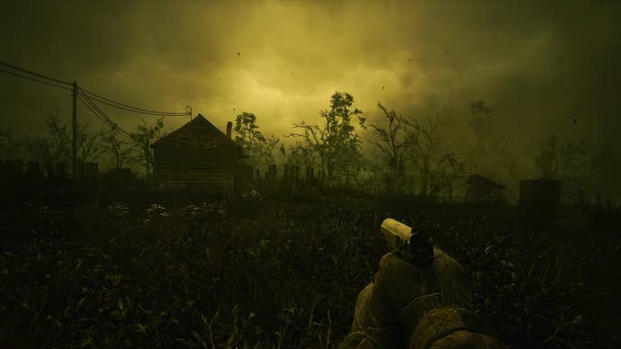 A player walks through an irradiated village under a green sky in Stalker 2
