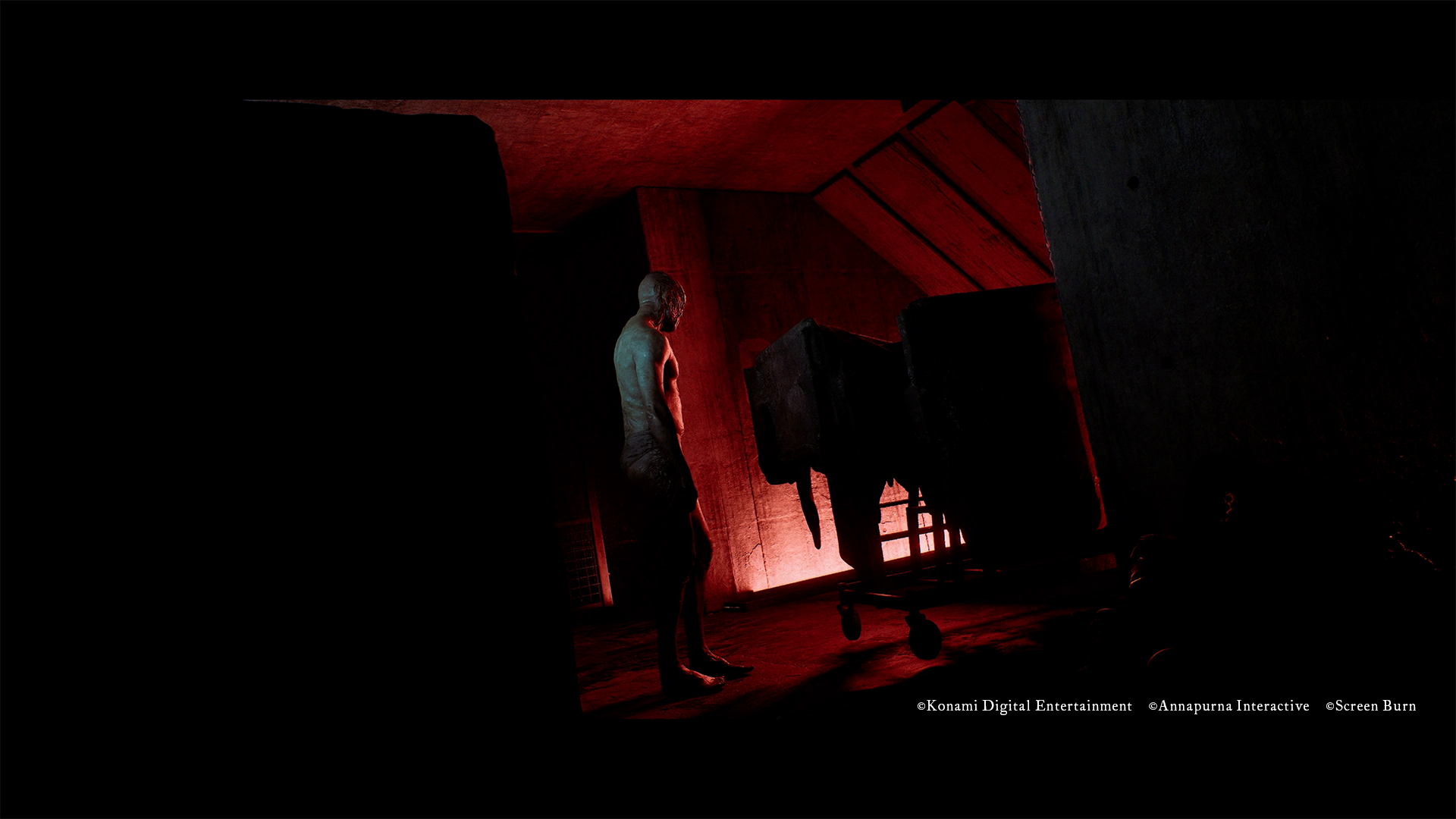 A pale, faceless humanoid figure stands beside an overturned gurney in a red-lit, sloped attic space.