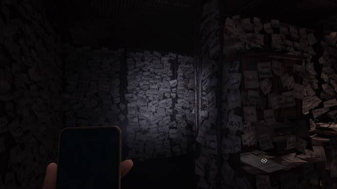 Silent Hill The Short Message Screenshot. The light from a mobile phone shows a room covered in sticky notes, all daubed with crude insults: stupid, loser, insane, ugly, creep, dumb etc.