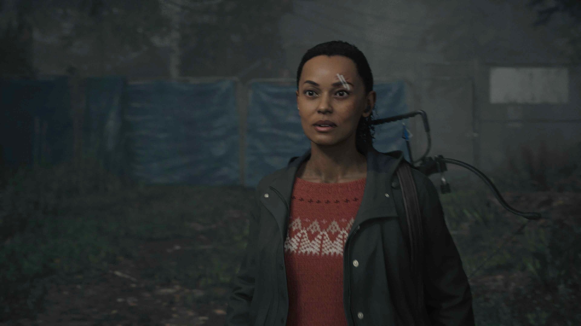 Screenshot of Alan Wake 2&rsquo;s Saga Anderson, wearing a red knitted sweater and black waterproof jacket, as she arrives at the trailer park in Watery.